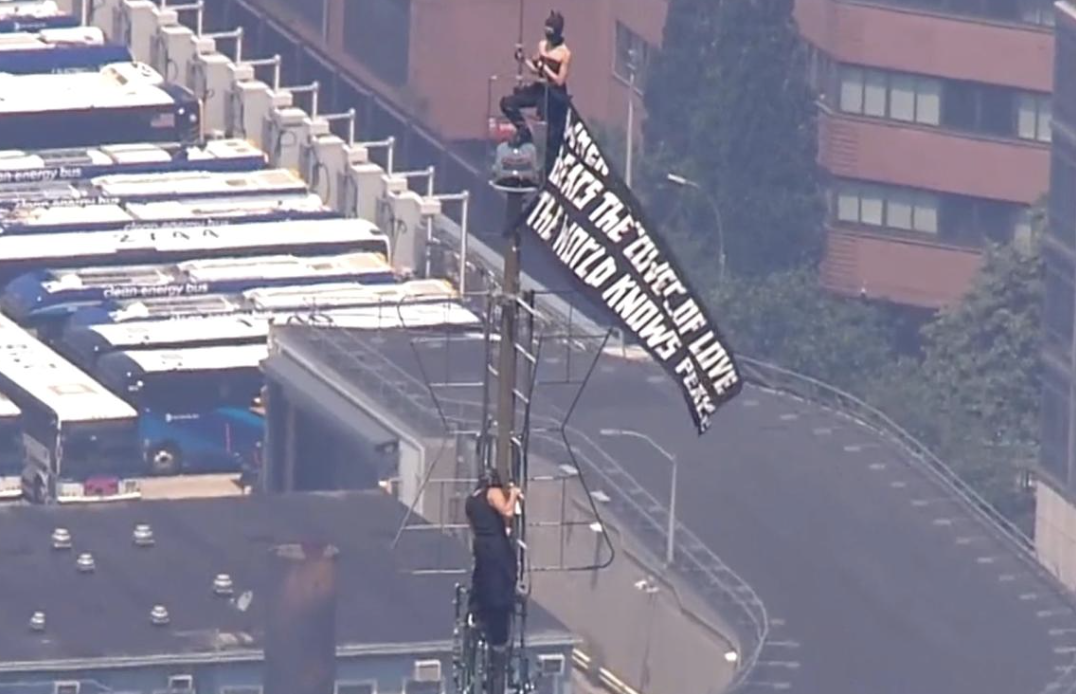 Two People in Masks Climb Atop Empire State Building